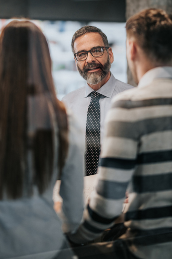 Two people talking to a banker
